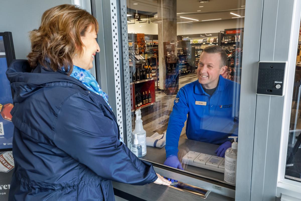 liquor Mart customer showing ID to a Liquor Mart employee