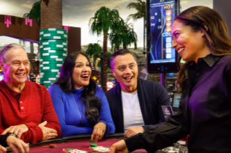 Dealer at a casino games table interacting with three casino patrons.