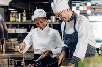 Two chefs preparing a meal in a commercial kitchen.