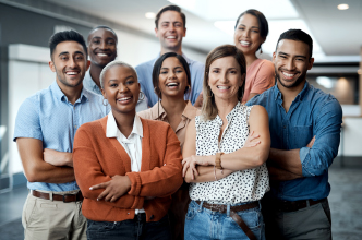 A group of coworkers facing forward with their arms folded and smiling for the camera.