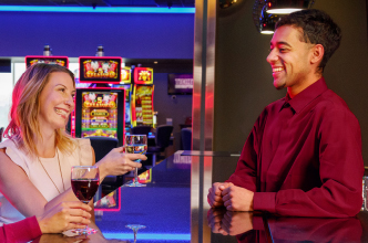 Casino patron enjoying a glass of wine and chatting with a casino staff person.